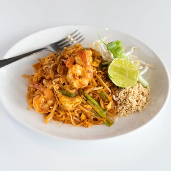 A plate of Rice Fine Thai Cuisine's shrimp Pad Thai with lime, bean sprouts, and crushed peanuts.